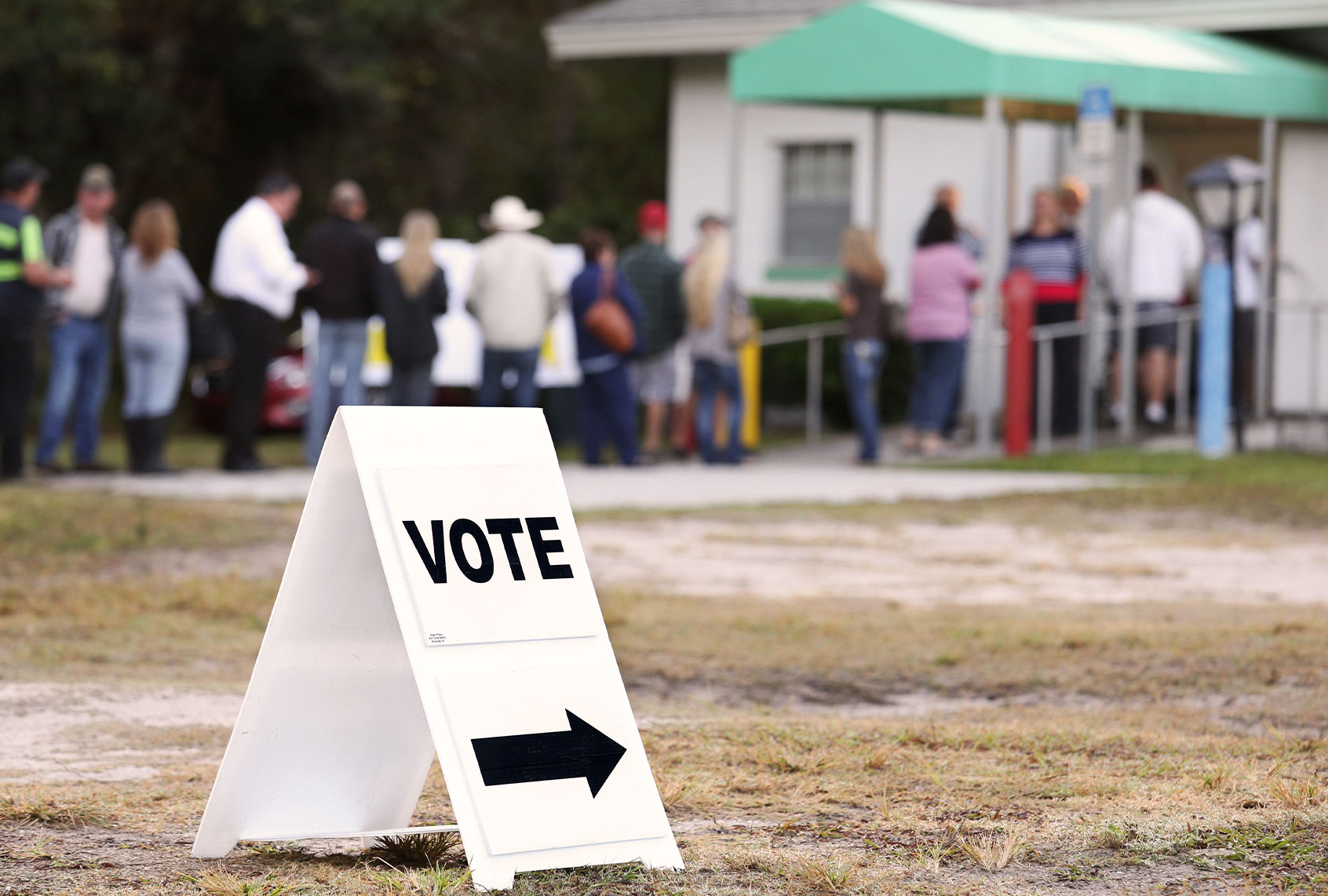 Voters wait in a queue to cast their ballots in the presidential election at a polling station in Christmas, Florida (GREGG NEWTON/AFP via Getty Images)