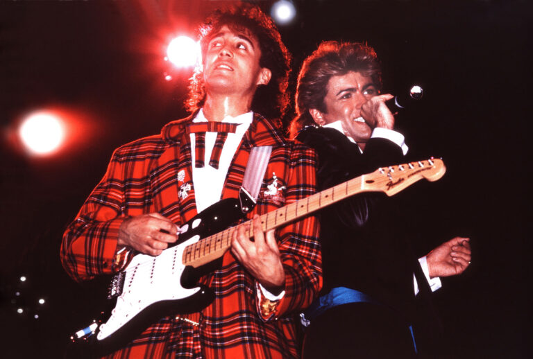 Andrew Ridgeley and George Michael of Wham! perform on stage in London, 1984. (Photo by Phil Dent/Redferns/Getty Images)