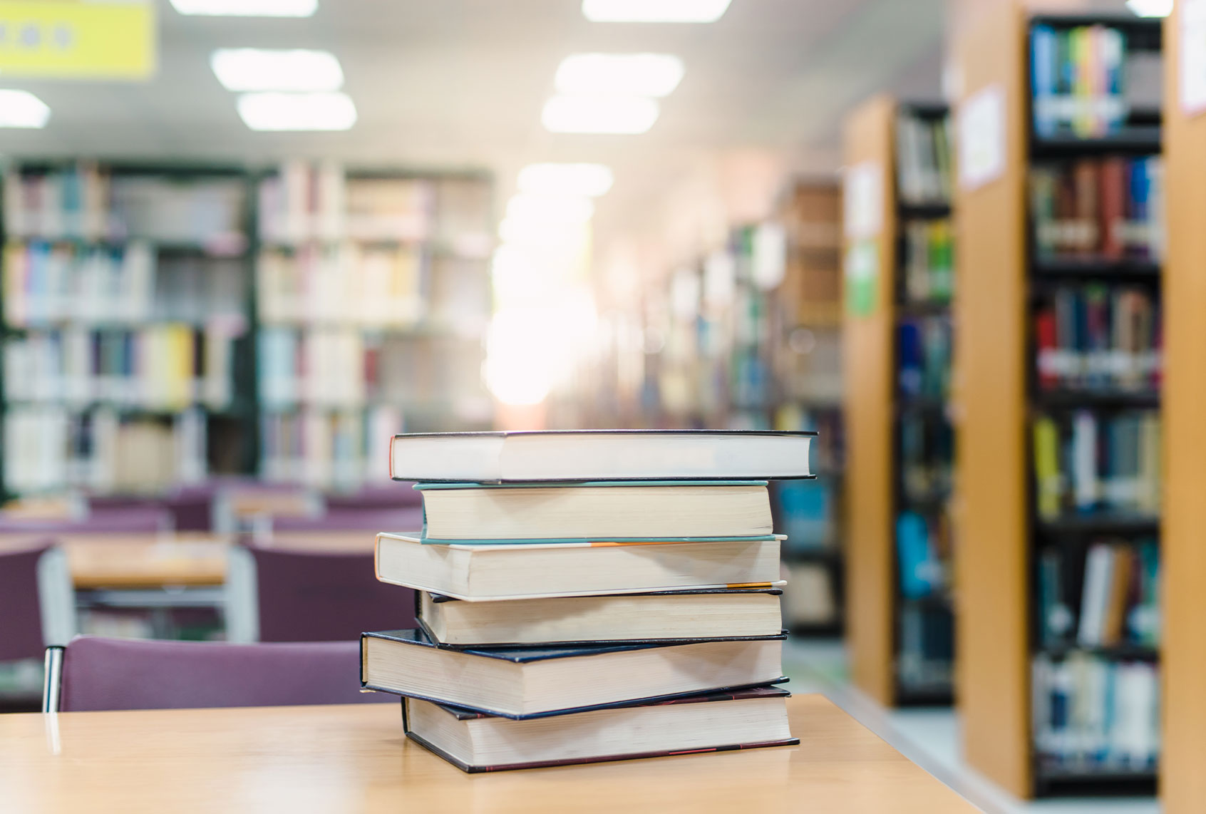 Stack Of Books On Table In Library (Getty Images/Rachan Panya/EyeEm)