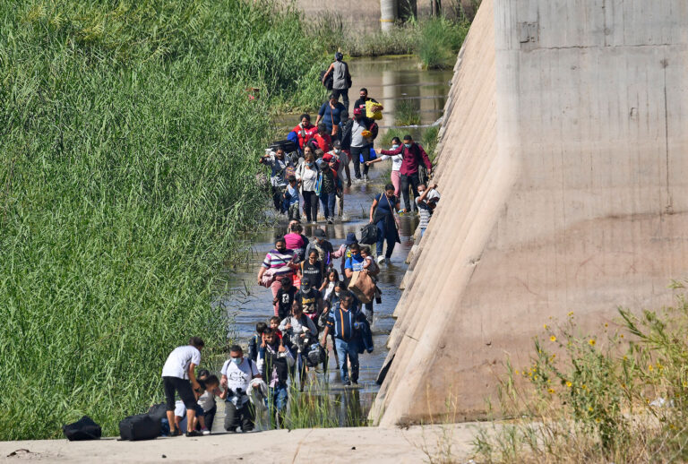 Migrants attempt to cross in to the U.S. from Mexico at the border October 10, 2021 in San Luis, Arizona. (Nick Ut/Getty Images)