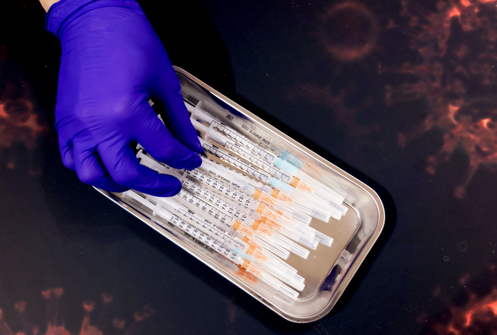 A medical assistant prepares syringes with the Pfizer/BioNTech vaccine against Covid-19 at the Humboldt Forum museum during the Omicron wave of the coronavirus pandemic on January 18, 2022 in Berlin, Germany. (Sean Gallup/Getty Images)