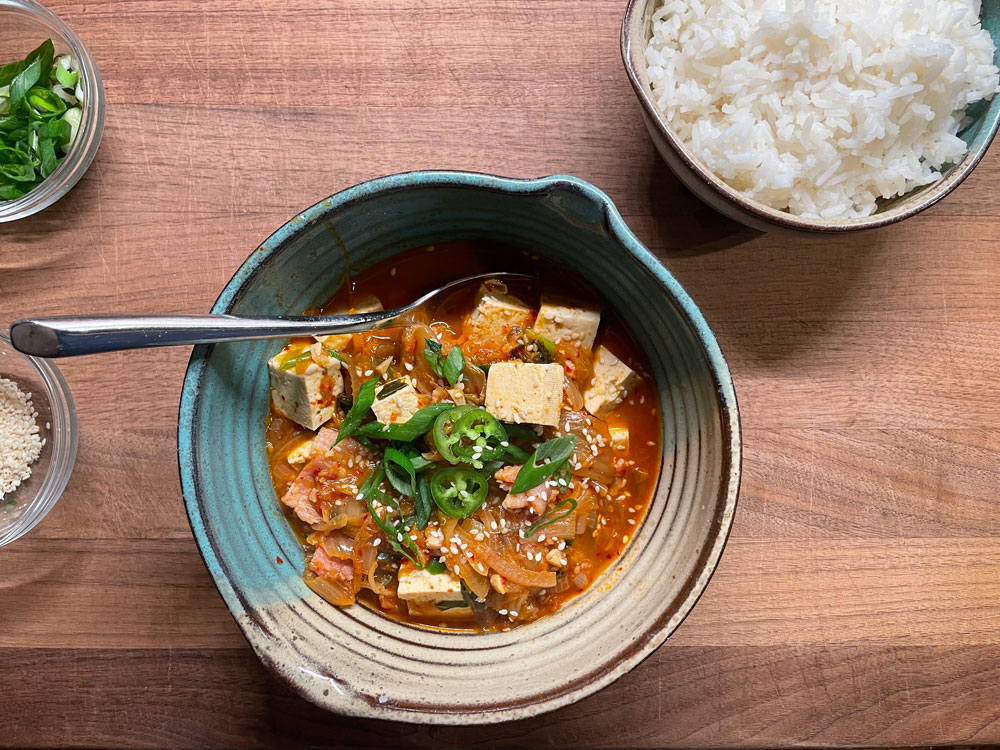 Kimchi Jjigae with garnishes (Photo courtesy of Maggie Hennessy)