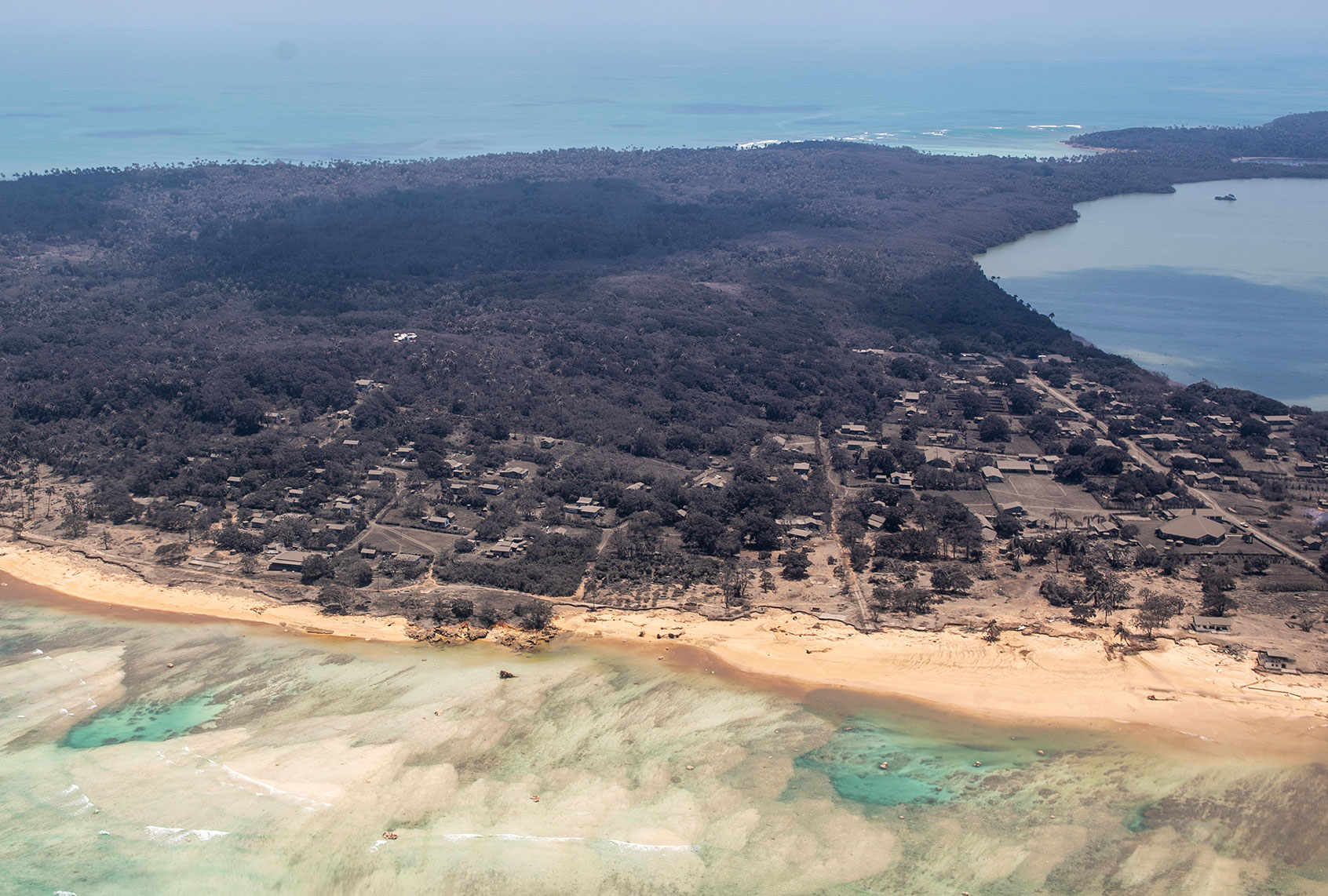 In this handout photo provided by the New Zealand Defense Force, an aerial view from a P-3K2 Orion surveillance flight of heavy ash fall on January 17, 2022 Nomuka, Tonga. A 5 Squadron crew work on board whilst flying overhead to provide vital information to send back to MFAT and various other government agencies. Tonga was struck by a tsunami caused by an undersea volcano erupting in the Pacific Ocean on January 15th. (New Zealand Defense Force via Getty Images)