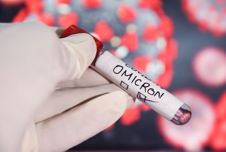A health worker wearing gloves holding a test sample tubes labeled 'COVID-19 Omicron' (Getty Images/David Talukdar)