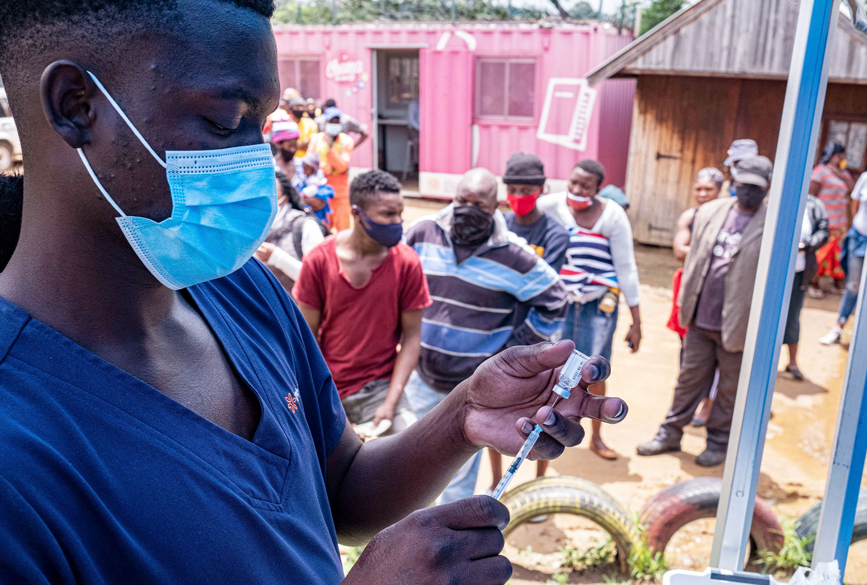 A health worker fills up a syringe with a vaccines dose against COVID-19 as people queue at the Kya Sands informal settlement to be vaccinated by the Witkoppen clinic in Johannesburg on December 8, 2021. - Anti-Covid vaccines may lose effectiveness against Omicron, but one more dose could remedy this. Initial elements, notably given by the Pfizer laboratory, shed light on the capacity of the new variant to resist vaccination. Omicron is "probably not sufficiently neutralized after two doses", admitted Wednesday the groups Pfizer and BioNTech, whose anti-Covid vaccine is given in two injections. (EMMANUEL CROSET/AFP via Getty Images)
