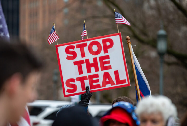 A protester holds a "stop the steal" placard during a pro-Trump demonstration. (Paul Weaver/SOPA Images/LightRocket via Getty Images)