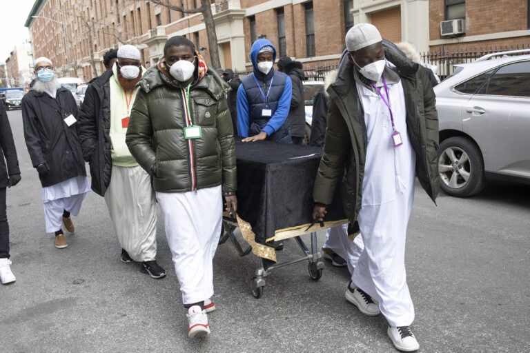 Caskets for 15 victims of a fire that killed 19 people in the Bronx are wheeled into the Islamic Cultural Center for a mass funeral on Jan. 16, 2022. (Andrew Lichtenstein/Corbis via Getty Images)