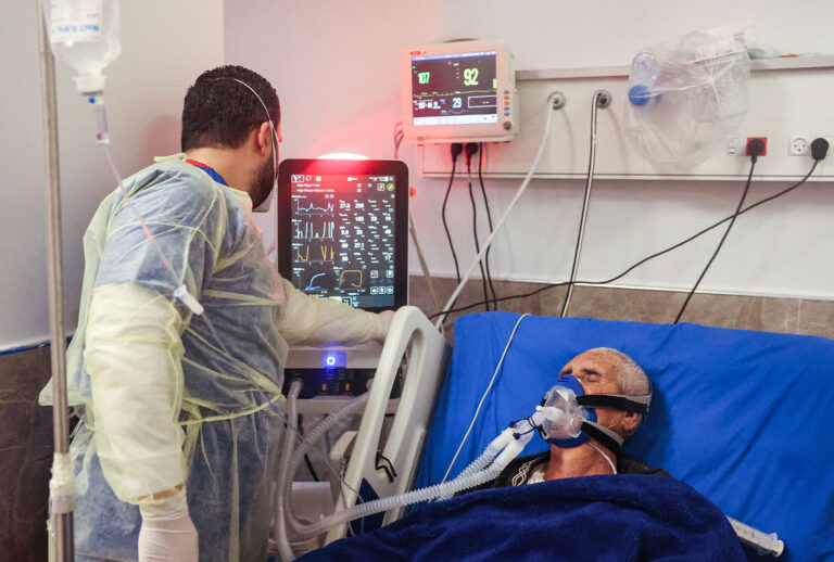 A medical worker monitors the vitals of an intubated patient at the COVID-19 coronavirus ward of Dura Governmental Hospital in the town of Dura on the outskirts of Hebron in the occupied West Bank on February 5, 2022. (HAZEM BADER/AFP via Getty Images)
