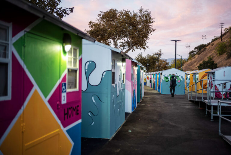 People tour the Arroyo Seco Tiny Home Village in Highland Park. The now completed 6.8-acre site within Arroyo Seco Park is the largest tiny home village in the United States, providing 117 housing units and 224 non-congregate beds as transitional residences for people experiencing homelessness in the Highland Park community. (Hans Gutknecht/MediaNews Group/Los Angeles Daily News via Getty Images)