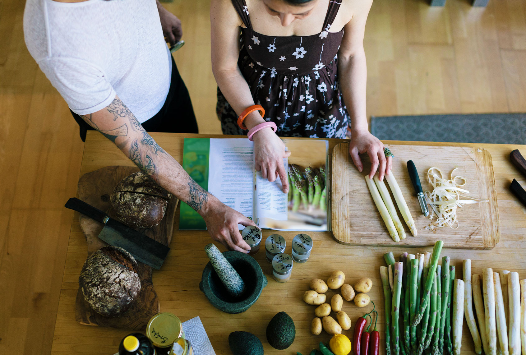 Overhead view of couple reading a cooking recipe (Getty Images/Hinterhaus Productions)