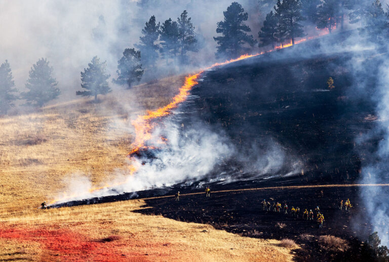 Firefighters battle the NCAR Fire on March 26, 2022 in Boulder, Colorado. The wildfire, which has forced almost 20,000 people to evacuate their homes, started just a few miles away from where the Marshall Fire destroyed more than 1,000 homes in December. (Michael Ciaglo/Getty Images)
