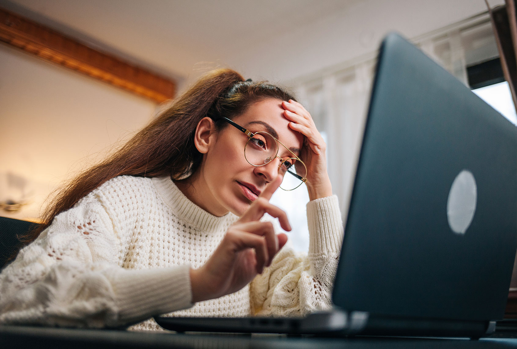 Stressed business woman working from home on laptop looking worried, tired and overwhelmed. (Getty Images/Nevena1987)
