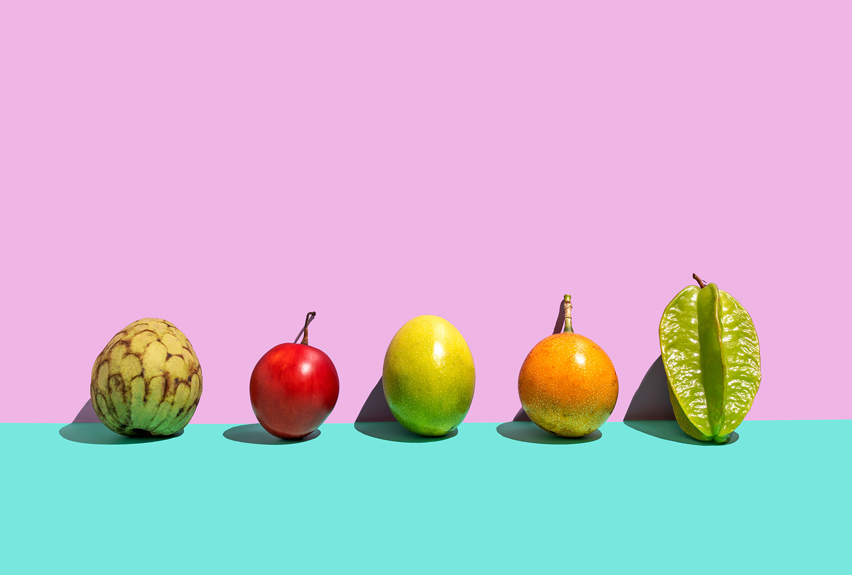 Variation of tropical fruits (Tamarillo,Carambola, passion fruit, cherimoya,passiflora singularis/grenadilla, mara) on the rose- turquoise background (Getty Images/Yulia Reznikov)