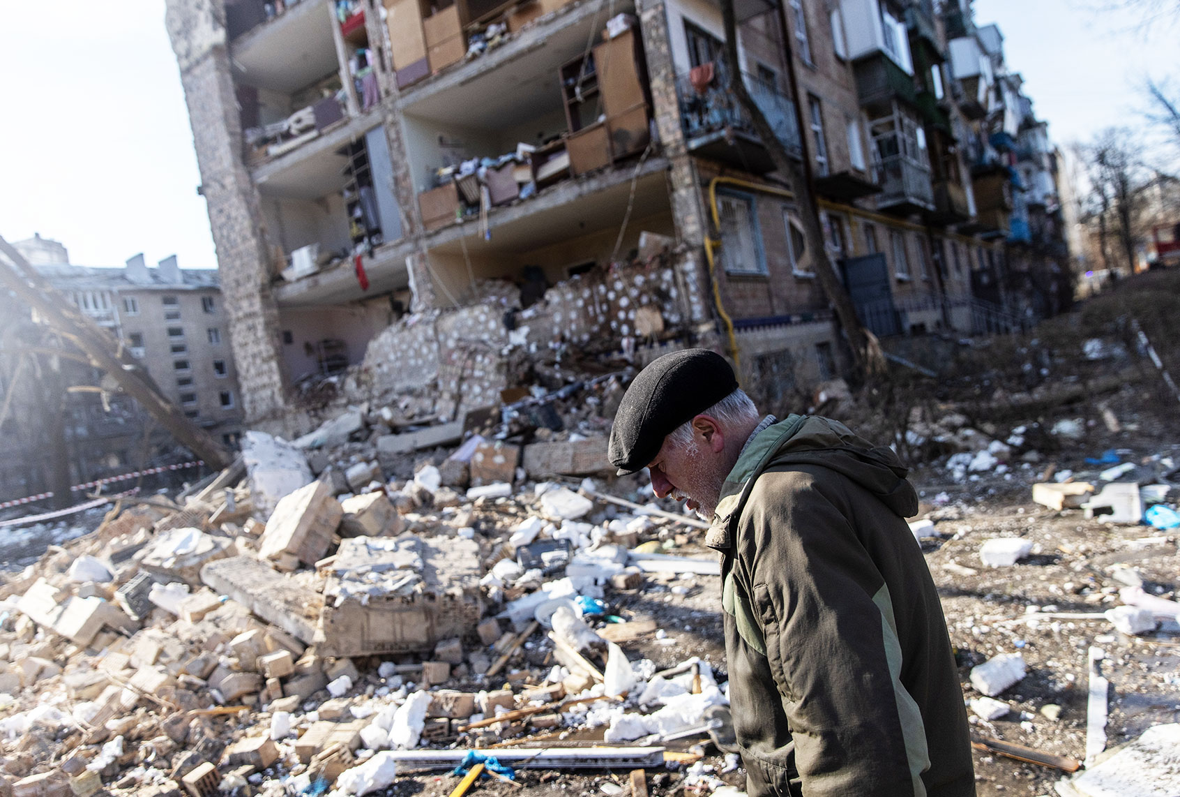 A man walks amid debris in front of a residential apartment complex that was heavily damaged by a Russian attack on March 18, 2022 in Kyiv, Ukraine. Russian forces remain on the outskirts of the Ukrainian capital, but their advance has stalled in recent days, even while Russian strikes - and pieces of intercepted missiles - have hit residential areas in the north of Kyiv. An estimated half of Kyiv's population has fled to other parts of the country, or abroad, since Russia invaded on February 24. (Chris McGrath/Getty Images)