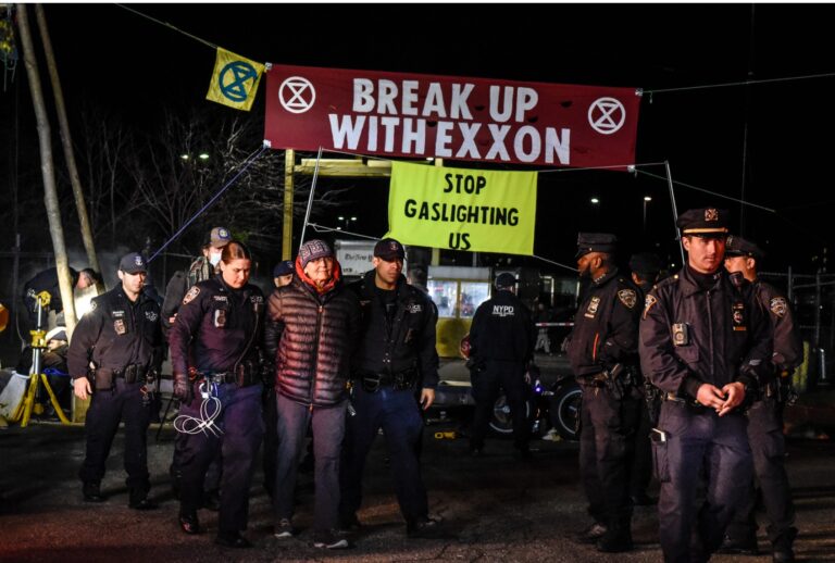 NEW YORK, NY - APRIL 22: New York City police officers detain members of environmental activist group Extinction Rebellion as they set up a blockade in front of the New York Times printing plant in the Flushing neighborhood of Queens on April 22, 2022 in New York City. Extinction Rebellion set up the blockade for several newspapers including The New York Times, The Wall Street Journal and The New York Post to call attention to what they consider the role media plays in the government's lack of response to the climate crisis. (Photo by Stephanie Keith/Getty Images)