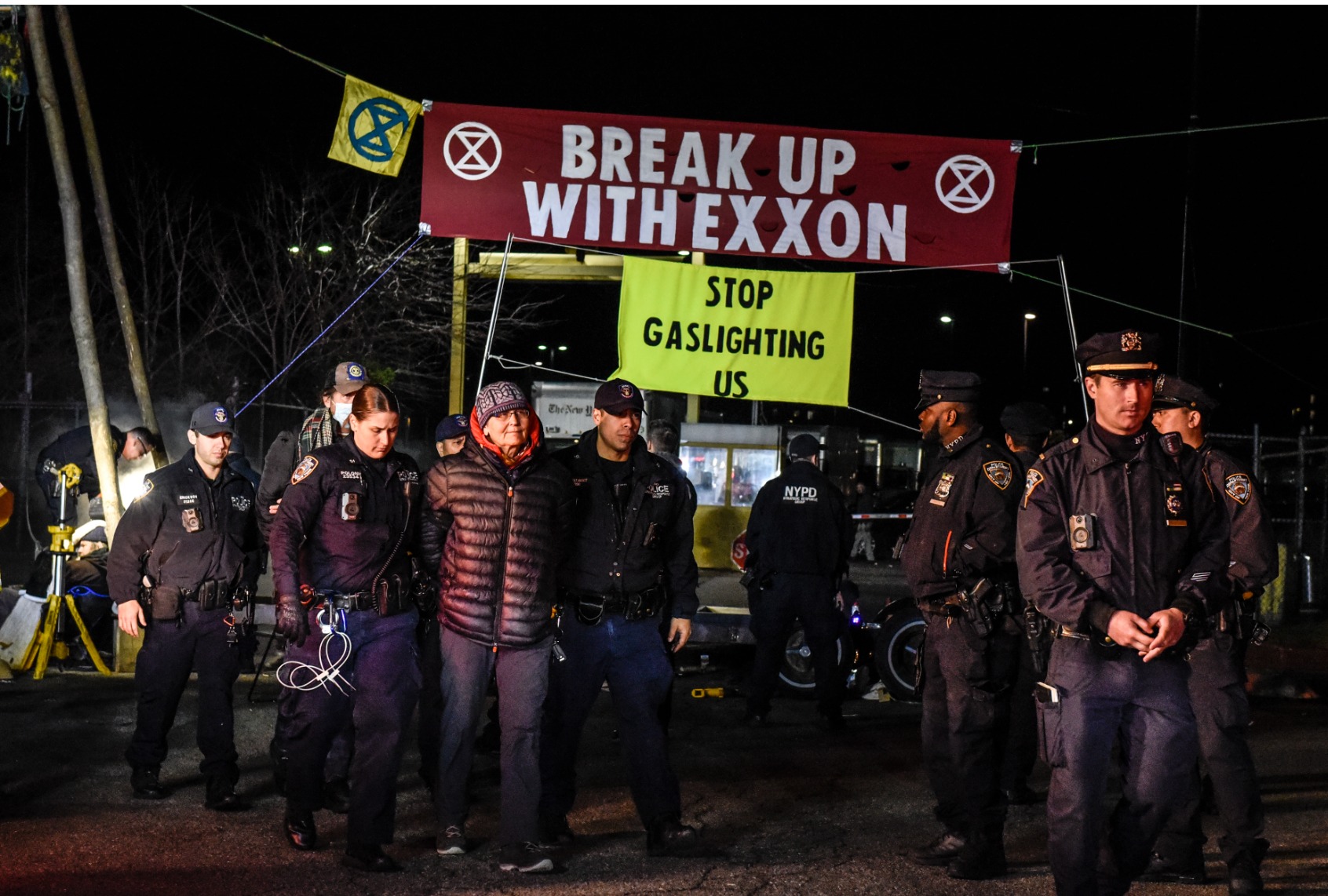 NEW YORK, NY - APRIL 22: New York City police officers detain members of environmental activist group Extinction Rebellion as they set up a blockade in front of the New York Times printing plant in the Flushing neighborhood of Queens on April 22, 2022 in New York City. Extinction Rebellion set up the blockade for several newspapers including The New York Times, The Wall Street Journal and The New York Post to call attention to what they consider the role media plays in the government's lack of response to the climate crisis. (Photo by Stephanie Keith/Getty Images)