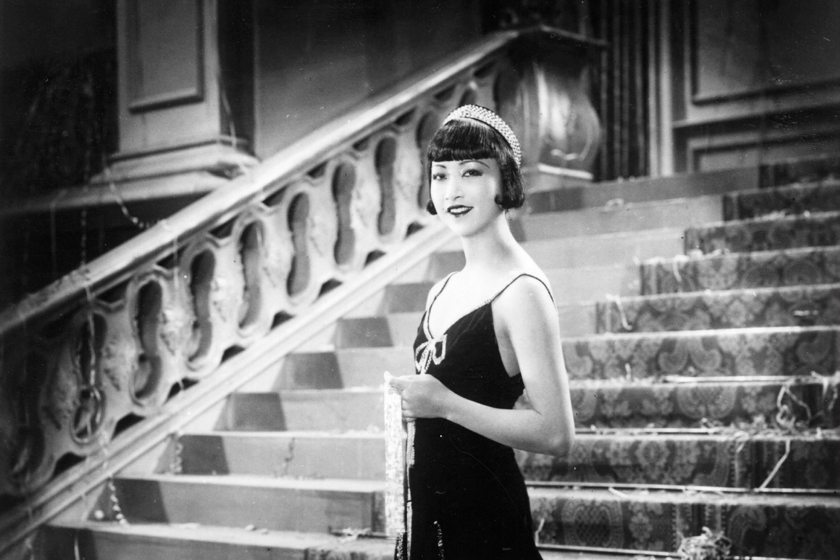 Chinese-American actress Anna May Wong (1907-1961), formerly Wong Liu Tsong, stands alone on a grand staircase in a scene from an unknown film. (General Photographic Agency/Getty Images)