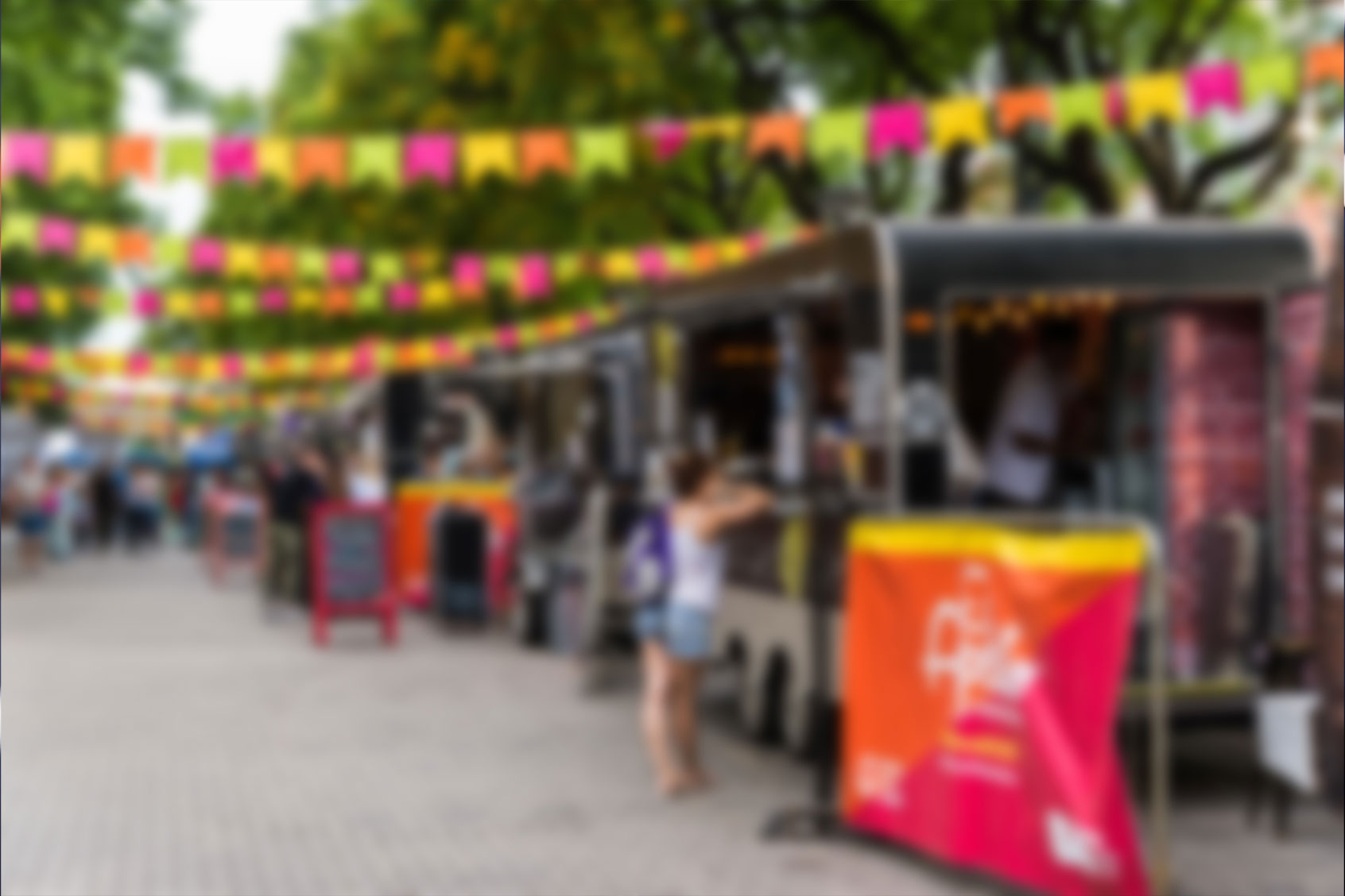 Food trucks and people at a street food market festival on a sunny day, blurred (Getty Images/Aleksandr_Vorobev)