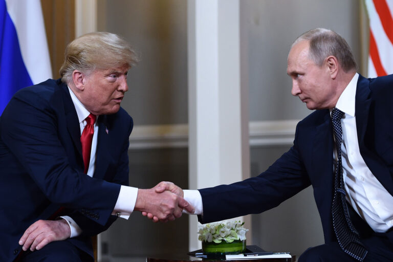 Russian President Vladimir Putin (R) and US President Donald Trump shake hands before a meeting in Helsinki, on July 16, 2018. (BRENDAN SMIALOWSKI/AFP via Getty Images)