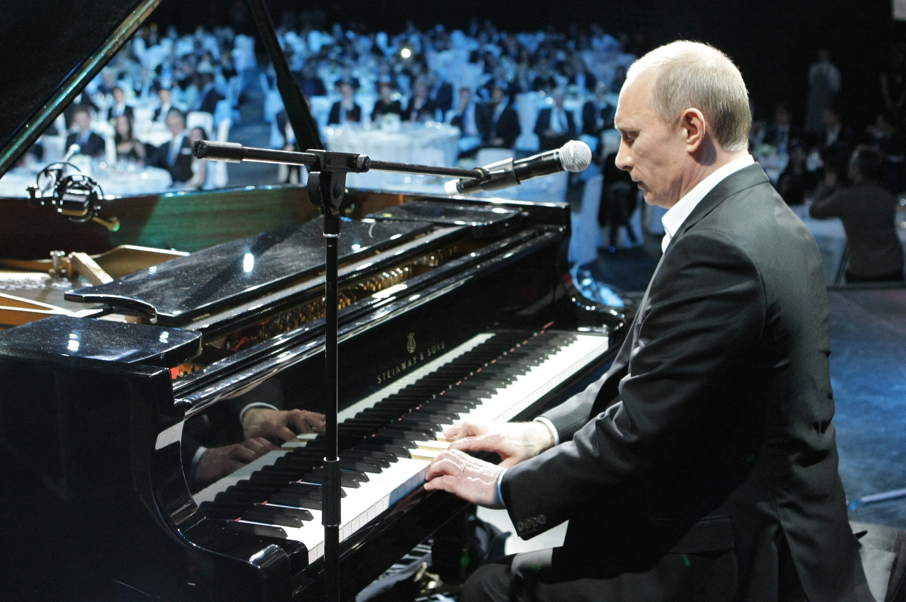 Russian Prime Minister Vladimir Putin plays piano during a charity concert in Saint Petersburg (Photo by ALEXEY NIKOLSKY/RIA NOVOSTI/AFP via Getty Images)