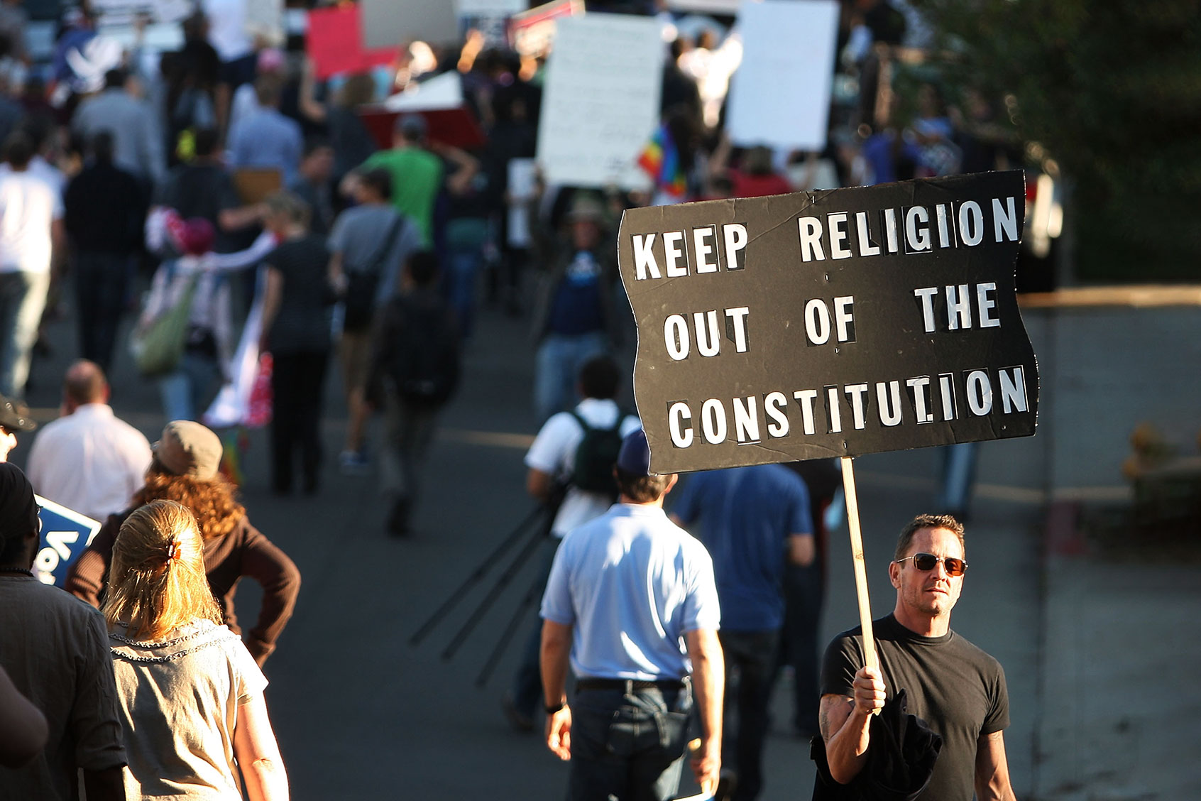 A man holding a sign reading "Keep Religion Out Of The Consitution." Hundreds of supporters of same-sex marriage march for miles in protest against the Church of Jesus Christ of Latter-day Saints November 6, 2008 in Los Angeles, California. (David McNew/Getty Images)