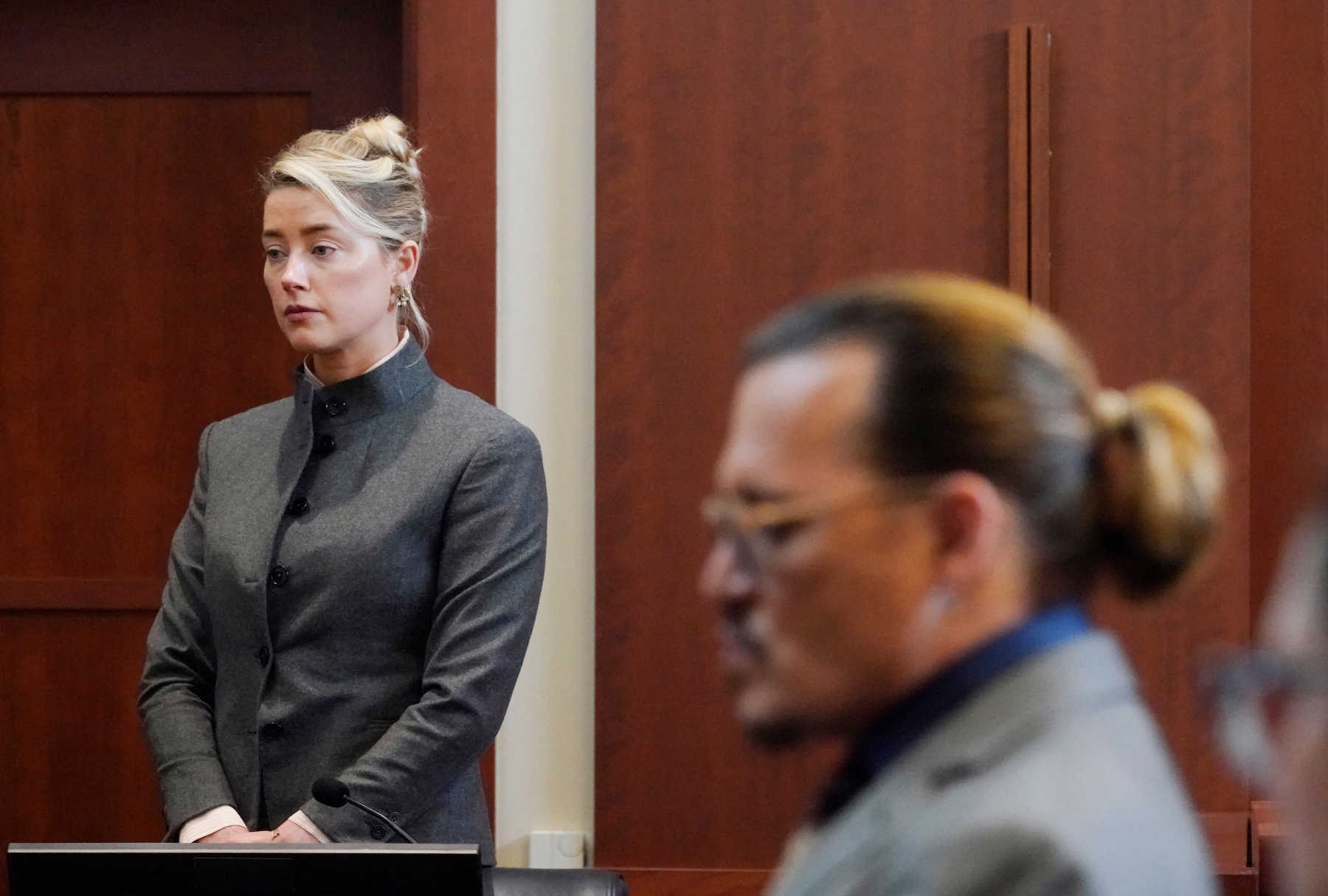 Amber Heard and Johnny Depp watch as the jury leave the courtroom for a lunch break at the Fairfax County Circuit Courthouse in Fairfax, Virginia, on May 16, 2022 (STEVE HELBER/POOL/AFP via Getty Images)