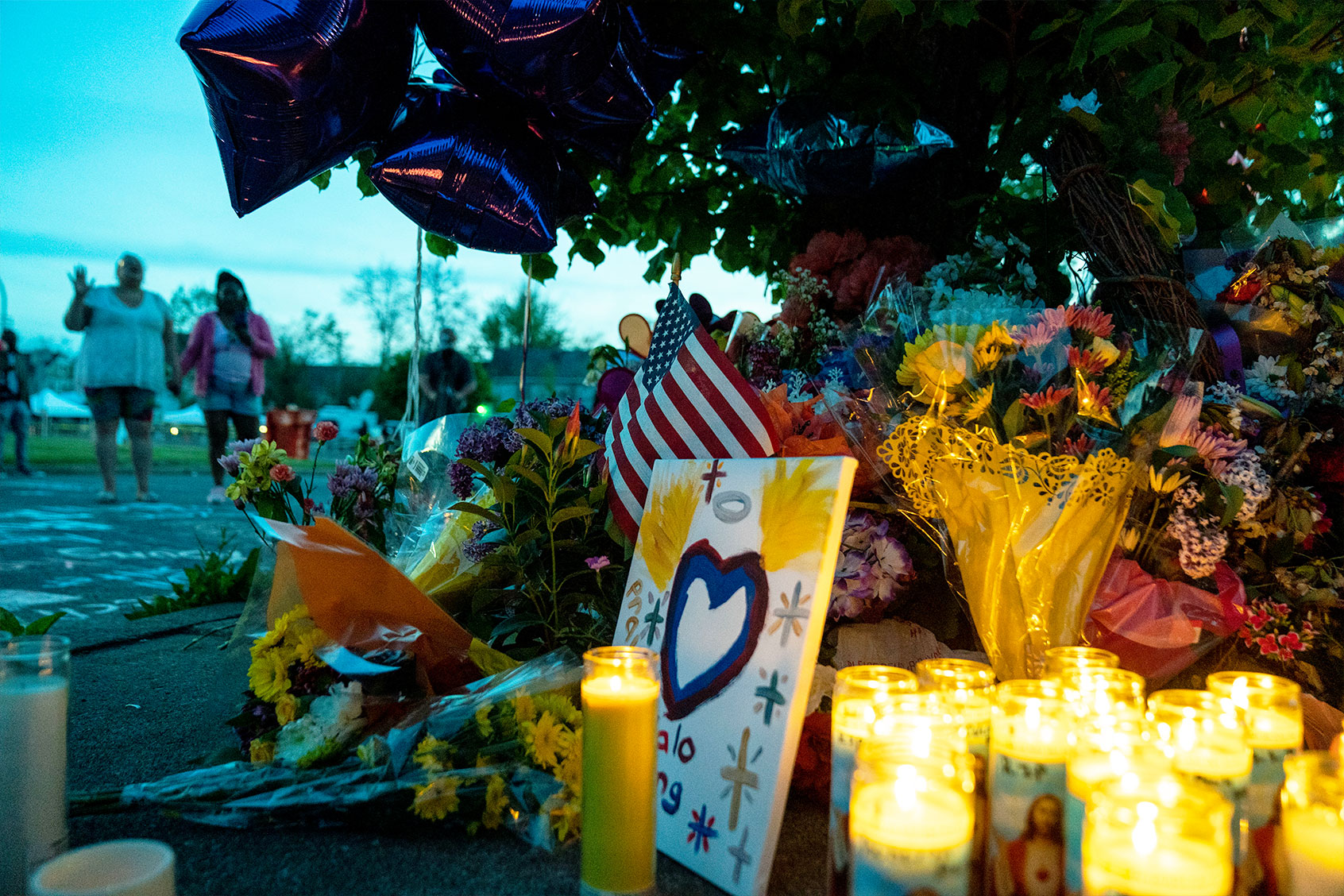 People gather at the scene of a mass shooting at Tops Friendly Market at Jefferson Avenue and Riley Street on Sunday, May 15, 2022 in Buffalo, NY. (Kent Nishimura / Los Angeles Times via Getty Images)