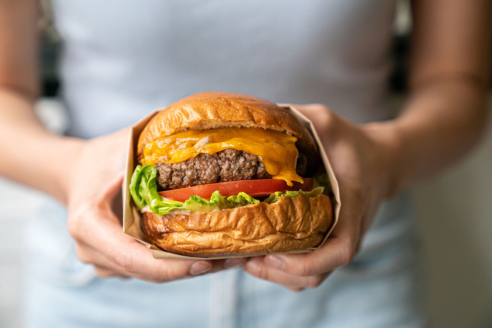 Woman holding a burger (Getty Images / pangshukman / 500px)
