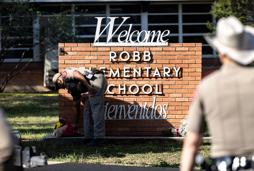 UVALDE, TX - MAY 25: A Texas State Trooper receives flowers for the victims of a mass shooting yesterday at Robb Elementary School where 21 people were killed, including 19 children, on May 25, 2022 in Uvalde, Texas. The shooter, identified as 18-year-old Salvador Ramos, was reportedly killed by law enforcement. (Photo by Jordan Vonderhaar/Getty Images)
