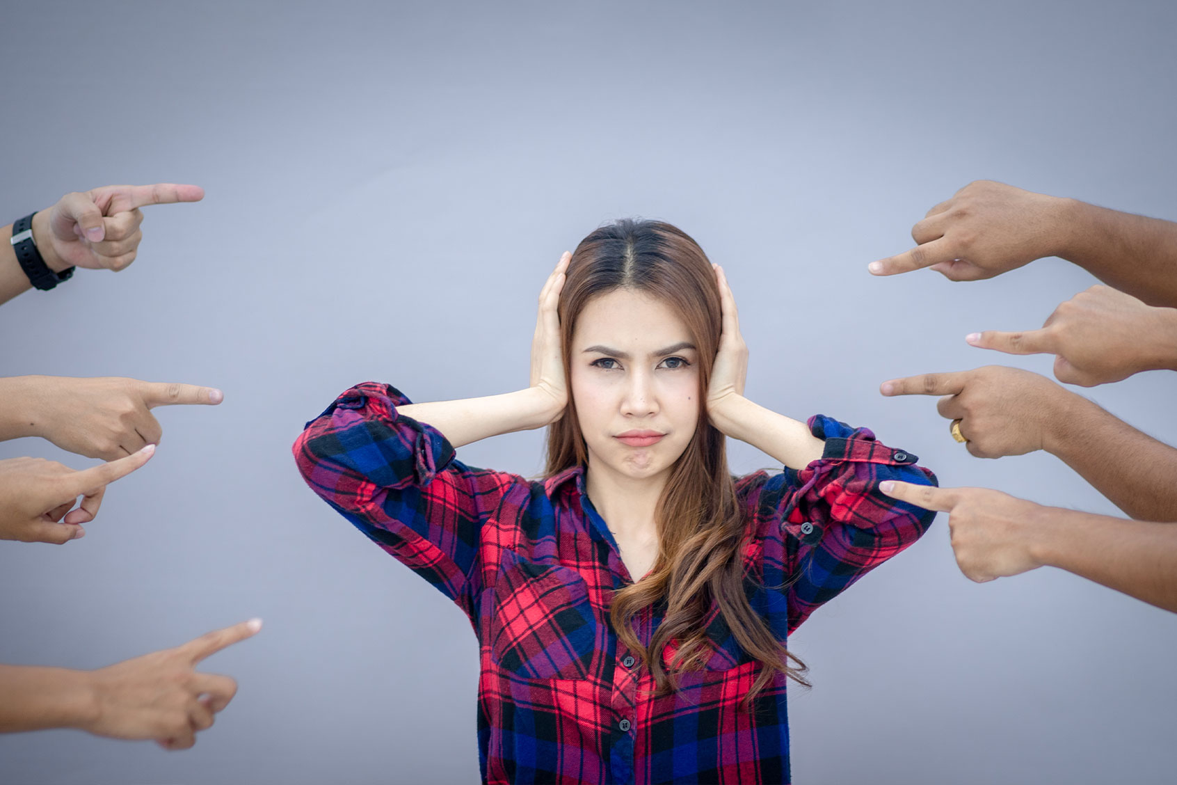 Woman being judged by different people pointing fingers at her (Getty Images/Tanaban chuenchay)