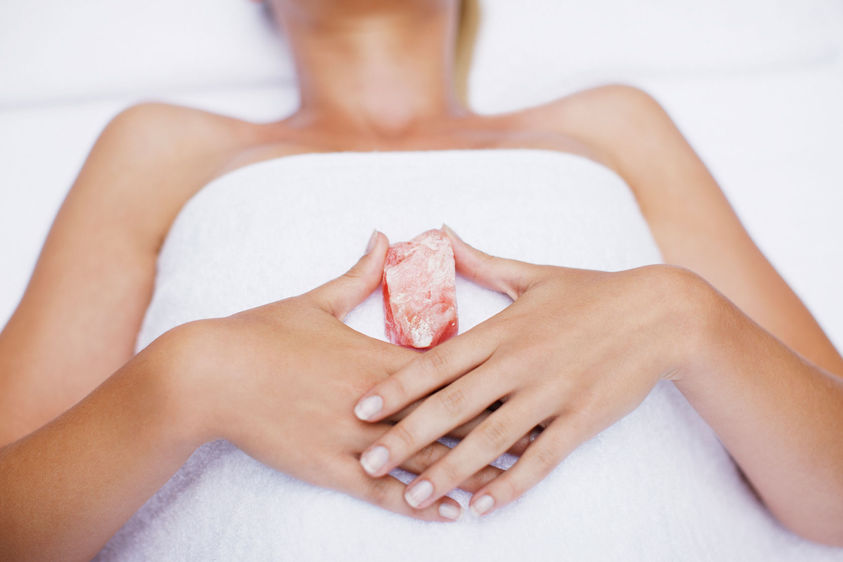 Woman laying with crystal (Getty Images/Tom Merton)