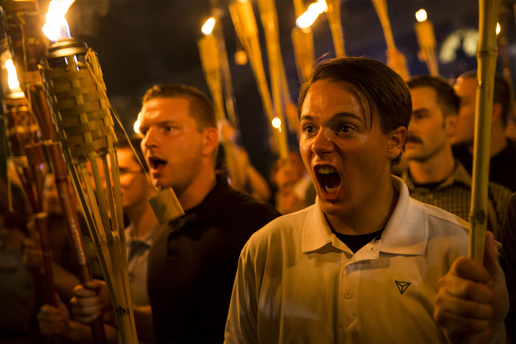 Peter Cvjetanovic (R) along with Neo Nazis, Alt-Right, and White Supremacists encircle and chant at counter protestors at the base of a statue of Thomas Jefferson after marching through the University of Virginia campus with torches in Charlottesville, Va., USA on August 11, 2017. (Samuel Corum/Anadolu Agency/Getty Images)