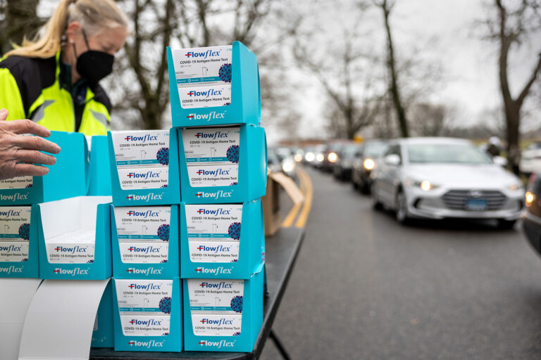 Residents line up at a drive-up distribution site to receive free at-home COVID-19 test kits on January 02, 2022 in Stamford, Connecticut. The Connecticut state government received some 400,000 tests over the weekend which were sent to cities and towns for local distribution. (John Moore/Getty Images)