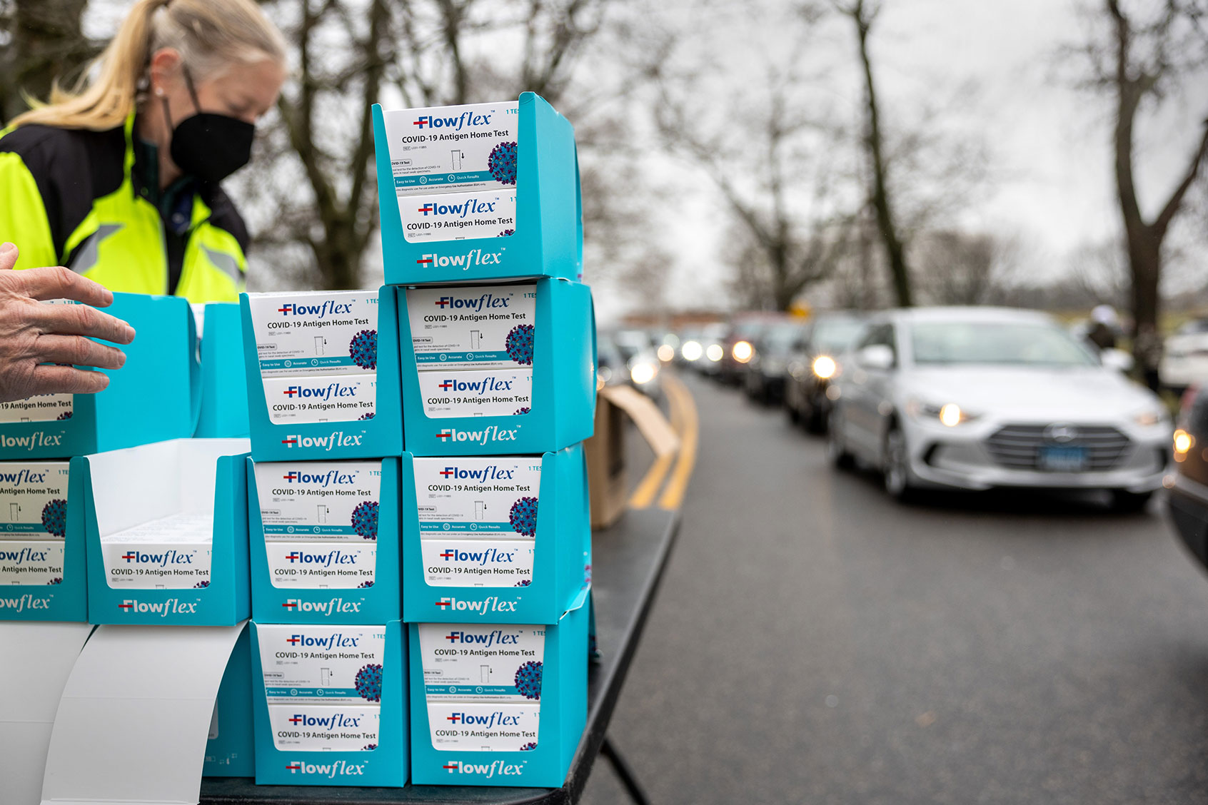 Residents line up at a drive-up distribution site to receive free at-home COVID-19 test kits on January 02, 2022 in Stamford, Connecticut. The Connecticut state government received some 400,000 tests over the weekend which were sent to cities and towns for local distribution. (John Moore/Getty Images)