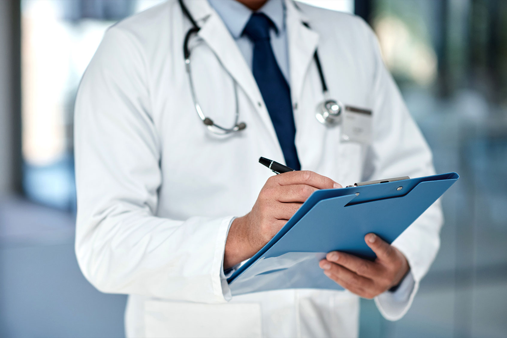 Doctor writing notes on a clipboard in a modern hospital (Getty Images/shapecharge)
