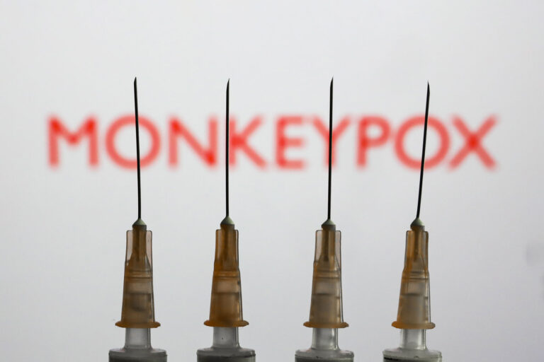 Medical syringes are seen with 'Monkeypox' sign displayed on a screen in the backgound in this illustration photo taken in Krakow, Poland on May 26, 2022. (Jakub Porzycki/NurPhoto via Getty Images)