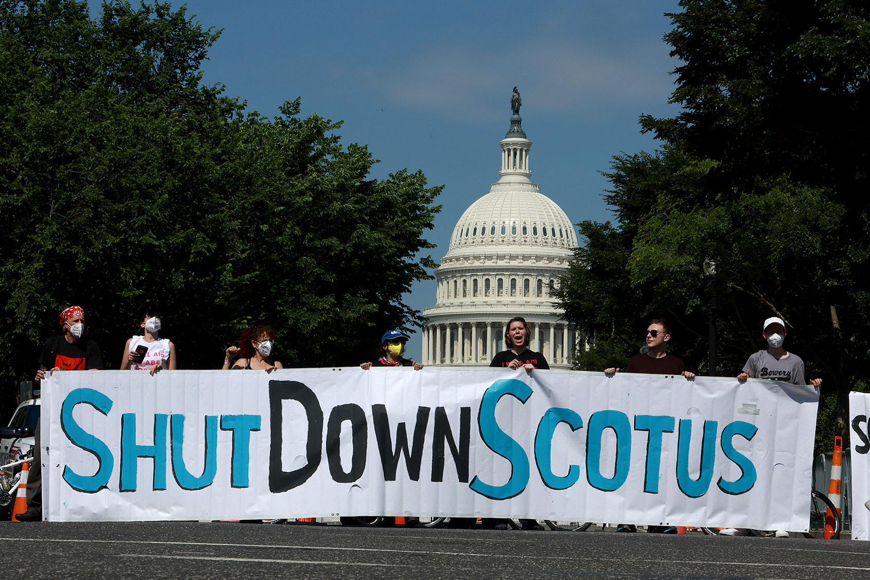 Protesters hold a banner near the U.S. Supreme Court on June 13, 2022 in Washington, DC. The court continues to release opinions as the country awaits major case decisions pertaining to abortion rights, guns, religion and climate change in the the coming weeks before the end of their term. (Joe Raedle/Getty Images)
