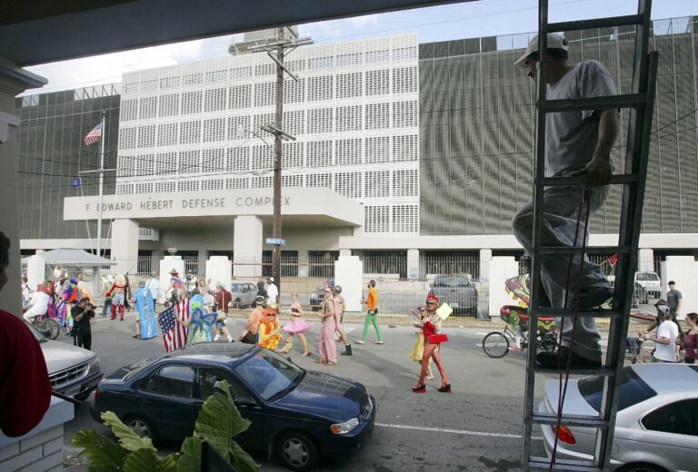 Workers watch while rebuilding a home damaged by Hurricane Katrina during an unofficial parade dubbed Krewe de Screwe in the Bywater neighborhood February 22, 2006 in New Orleans, Louisiana. (Mario Tama / Getty Images)