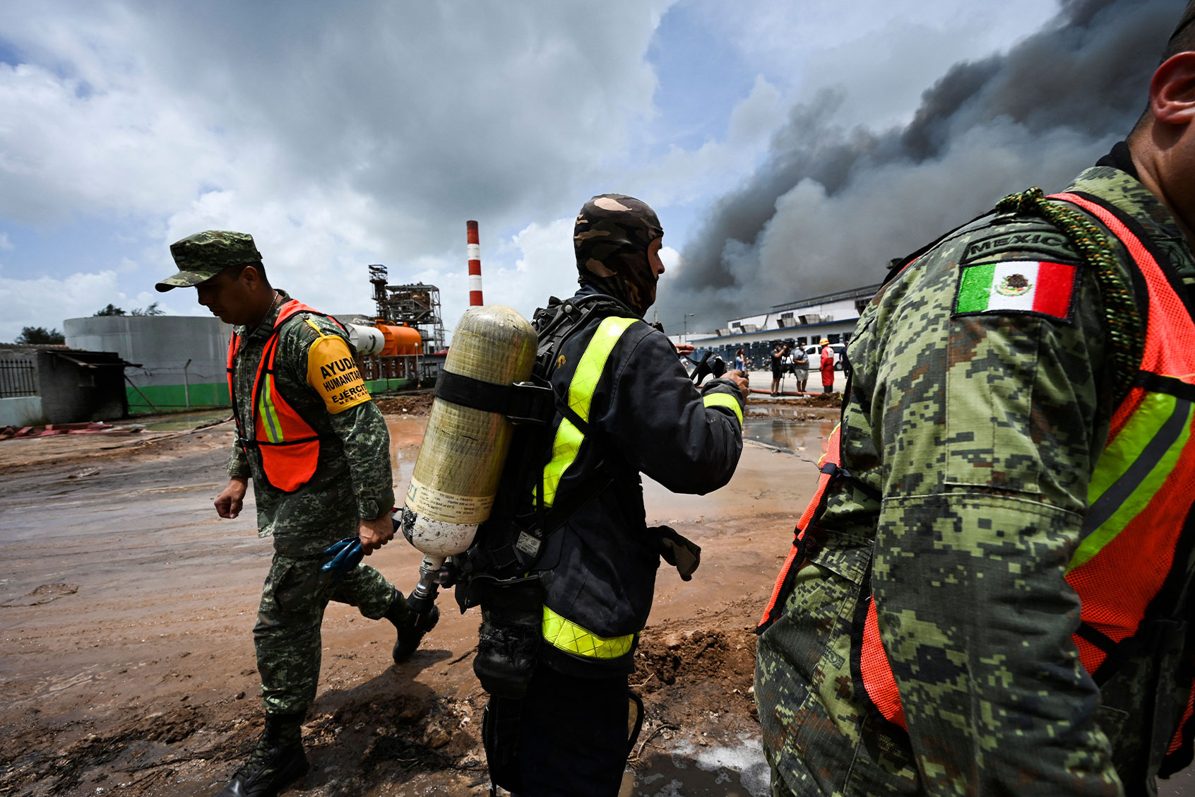 Mexican and Cuban firefighters working in the area where the massive fire at a fuel depot sparked by a lightning strike occurred in Matanzas, Cuba, on August 9, 2022. (YAMIL LAGE/AFP via Getty Images)
