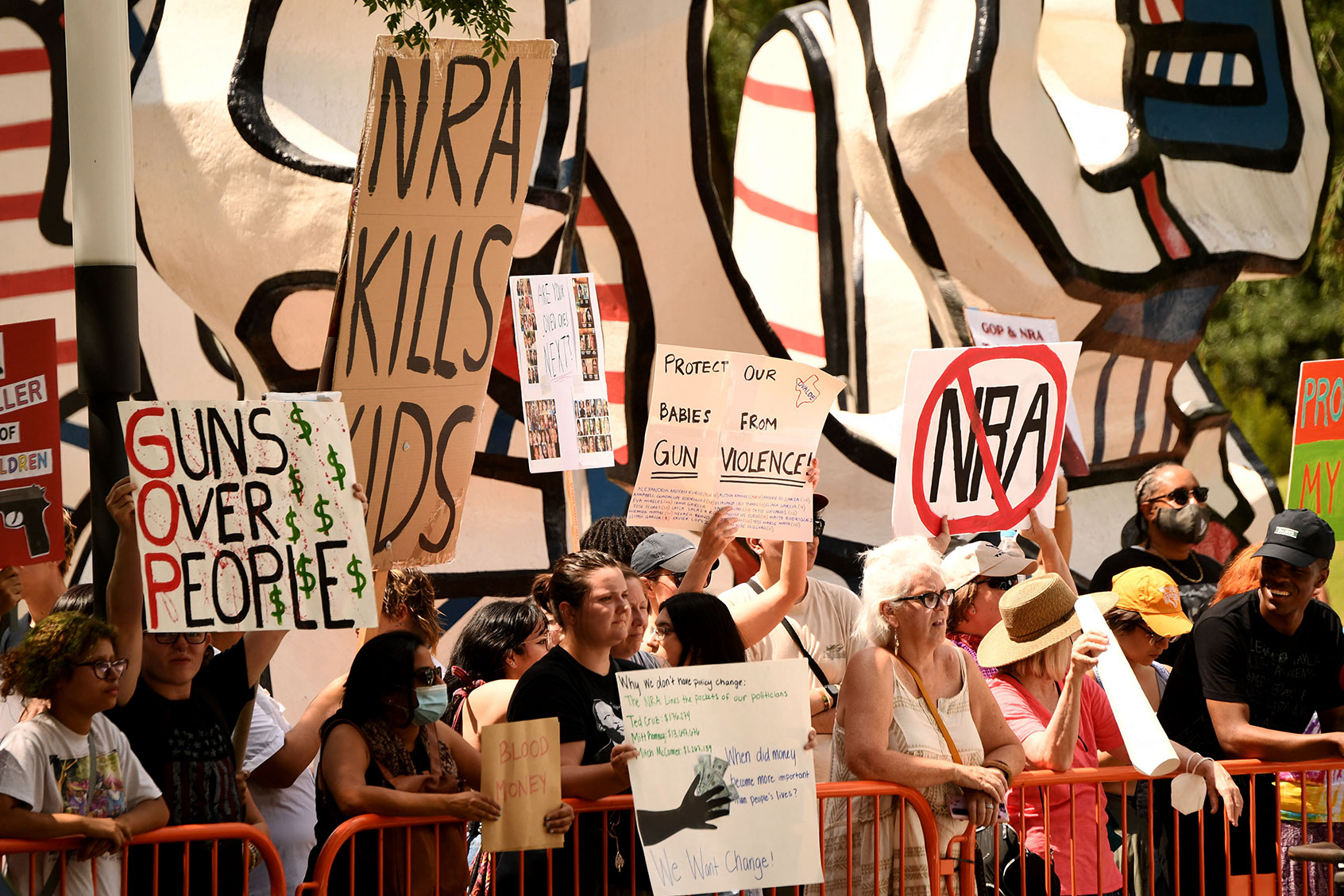 Protesters in support of gun control hold signs accross the National Rifle Association Annual Meeting at the George R. Brown Convention Center, on May 27, 2022, in Houston, Texas. (PATRICK T. FALLON/AFP via Getty Images)