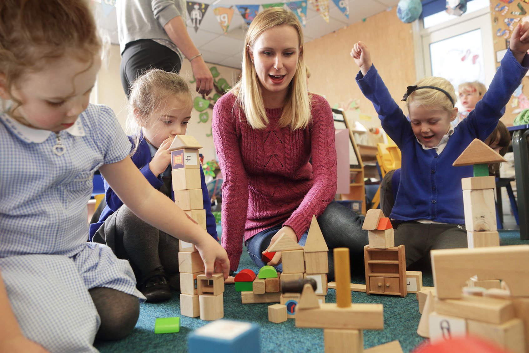 Teacher playing with children at school (Getty Images/Peter Cade)