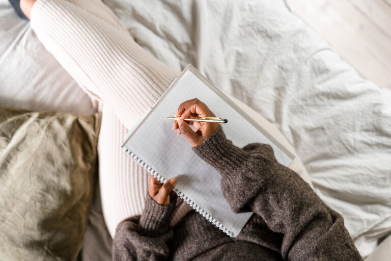 Woman writing in bed (Getty Images/luza studios)