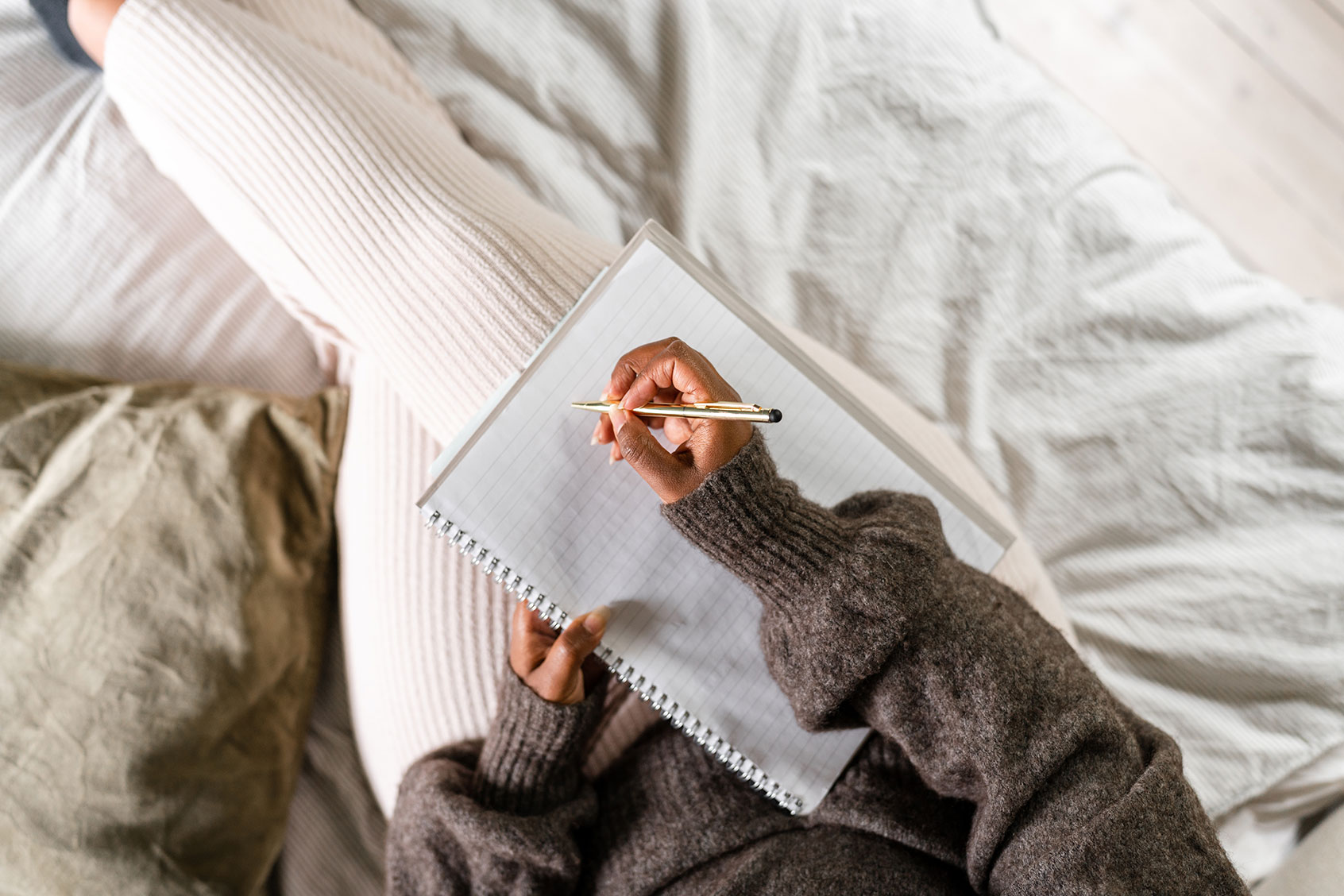 Woman writing in bed (Getty Images/luza studios)