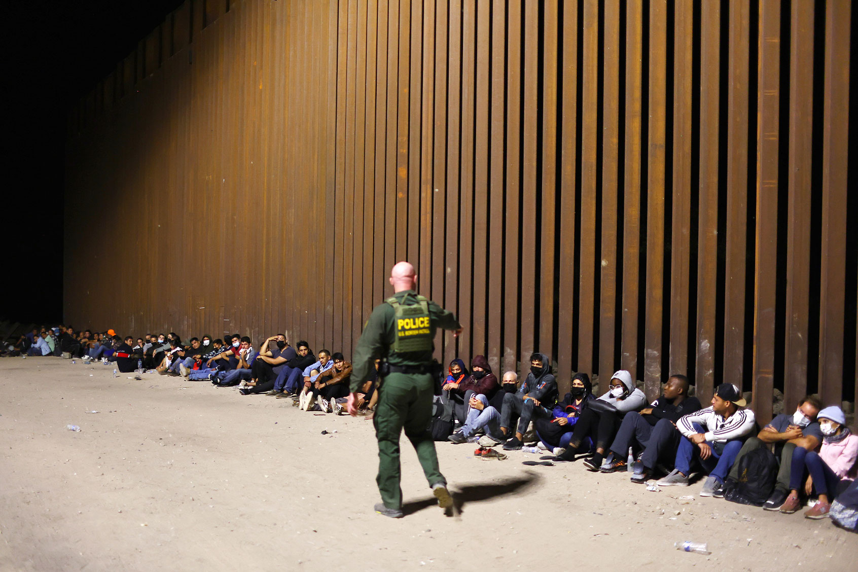 A U.S. Border Patrol agent monitors immigrants after they crossed the border with Mexico on May 18, 2022 in Yuma, Arizona. (Mario Tama/Getty Images)