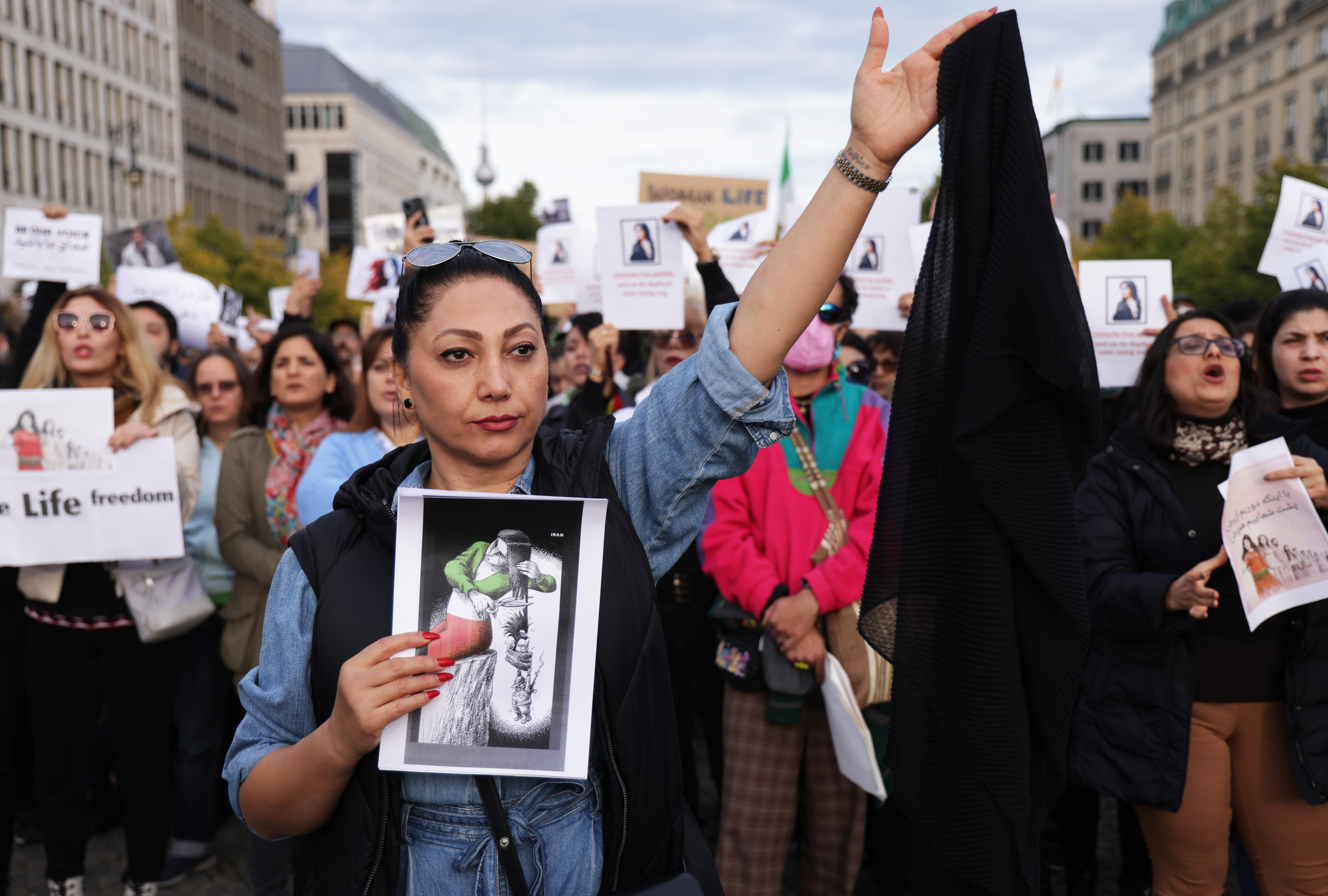 Protesters, including one woman holding up a headscarf, gather to demonstrate against the death of Mahsa Amini in Iran on September 23, 2022 in Berlin, Germany. (Sean Gallup/Getty Images)
