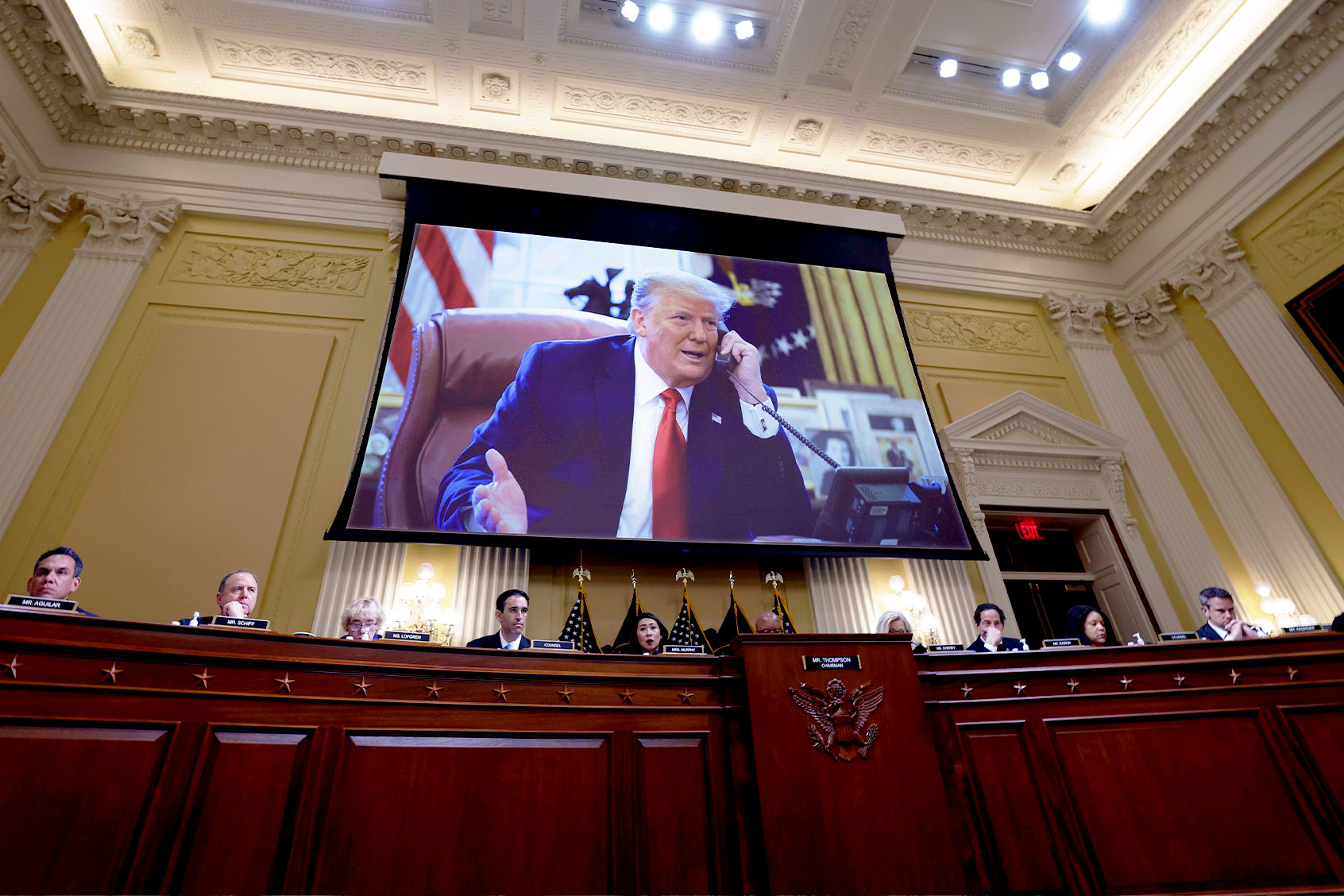 Former U.S. President Donald Trump appears on a video screen above members of the Select Committee to Investigate the January 6th Attack on the U.S. Capitol during the seventh hearing on the January 6th investigation in the Cannon House Office Building on July 12, 2022 in Washington, DC. (Kevin Dietsch/Getty Images)