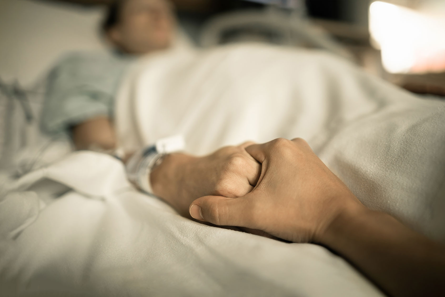 Holding hands in hospital bed (Getty Images/kieferpix)