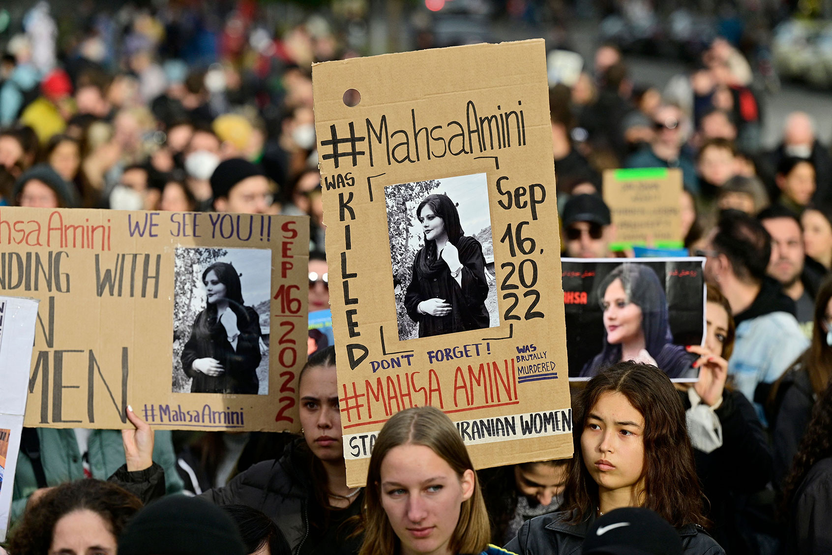 Demonstrators hold up placards with images of Kurdish Iranian woman Mahsa Amini who died while in the custody of Iran's morality police, during a demonstration in support of women and the Iranian protesters, on September 28, 2022. (JOHN MACDOUGALL/AFP via Getty Images)