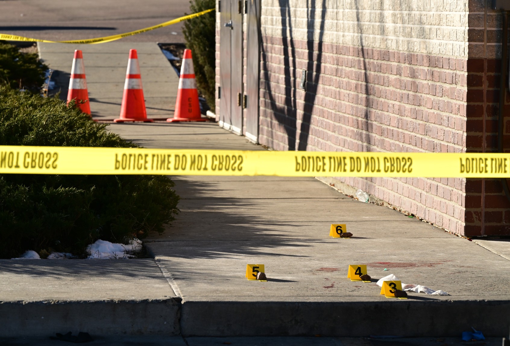 Evidence markers are placed at the scene near a 7-11 where a victim was found near Club Q on November 20, 2022 in Colorado Springs, Colorado. (Helen H. Richardson/MediaNews Group/The Denver Post via Getty Images)