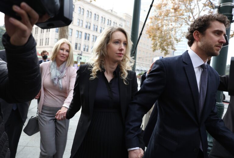 Former Theranos CEO Elizabeth Holmes (C) arrives at federal court with her partner Billy Evans (R) and mother Noel Holmes on November 18, 2022 in San Jose, California. (Justin Sullivan/Getty Images)